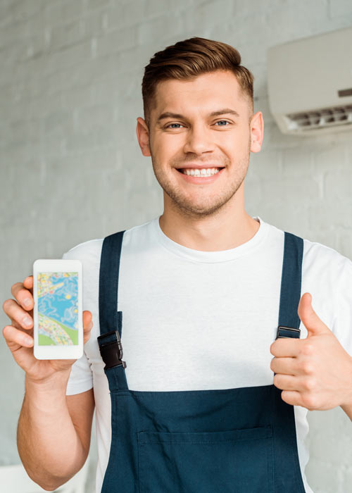 cheerful-HVAC-installer-showing-thumb-up-while-holding-phone